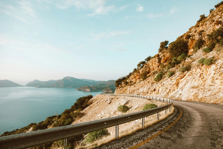 a road on the side of a mountain next to a body of water, by Lee Loughridge, pexels contest winner, mediterranean vista, 2 5 6 x 2 5 6 pixels, turkey, half turned around