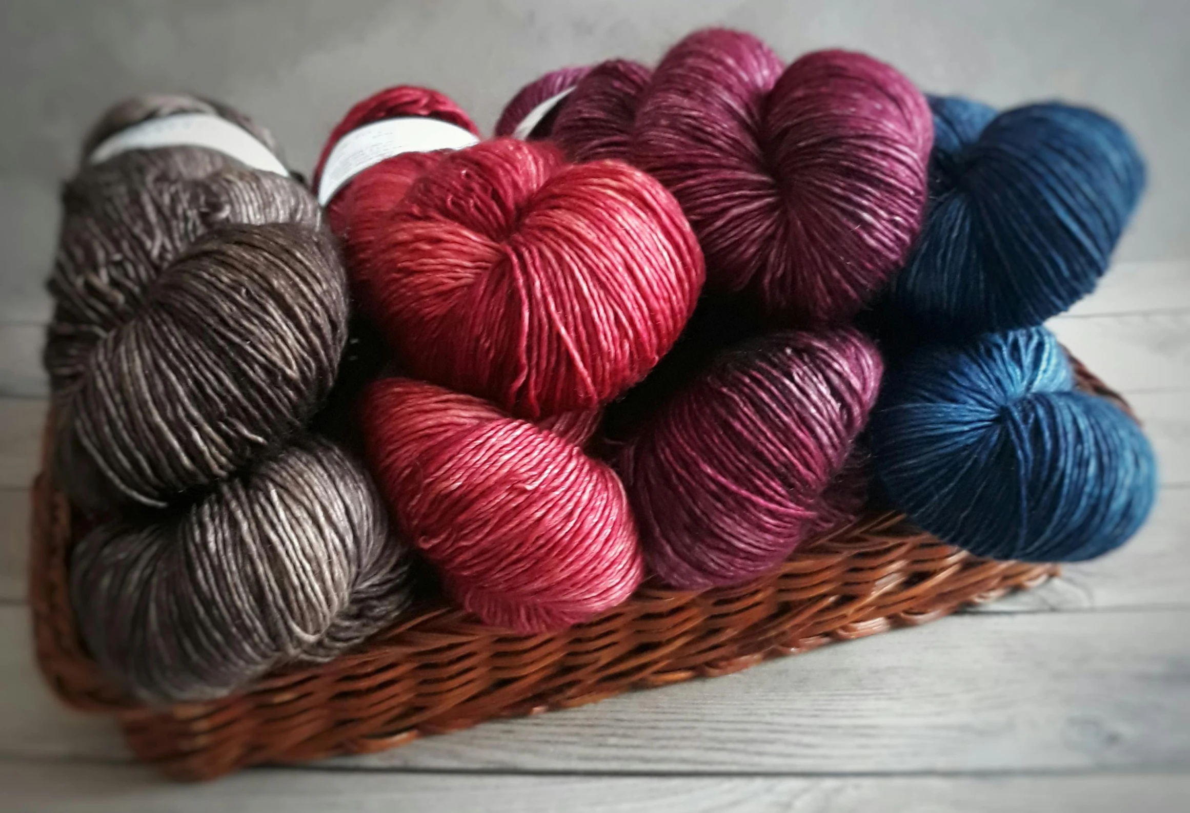 a basket filled with yarn on top of a wooden table, silk colors, crimson, thumbnail, sakimichan