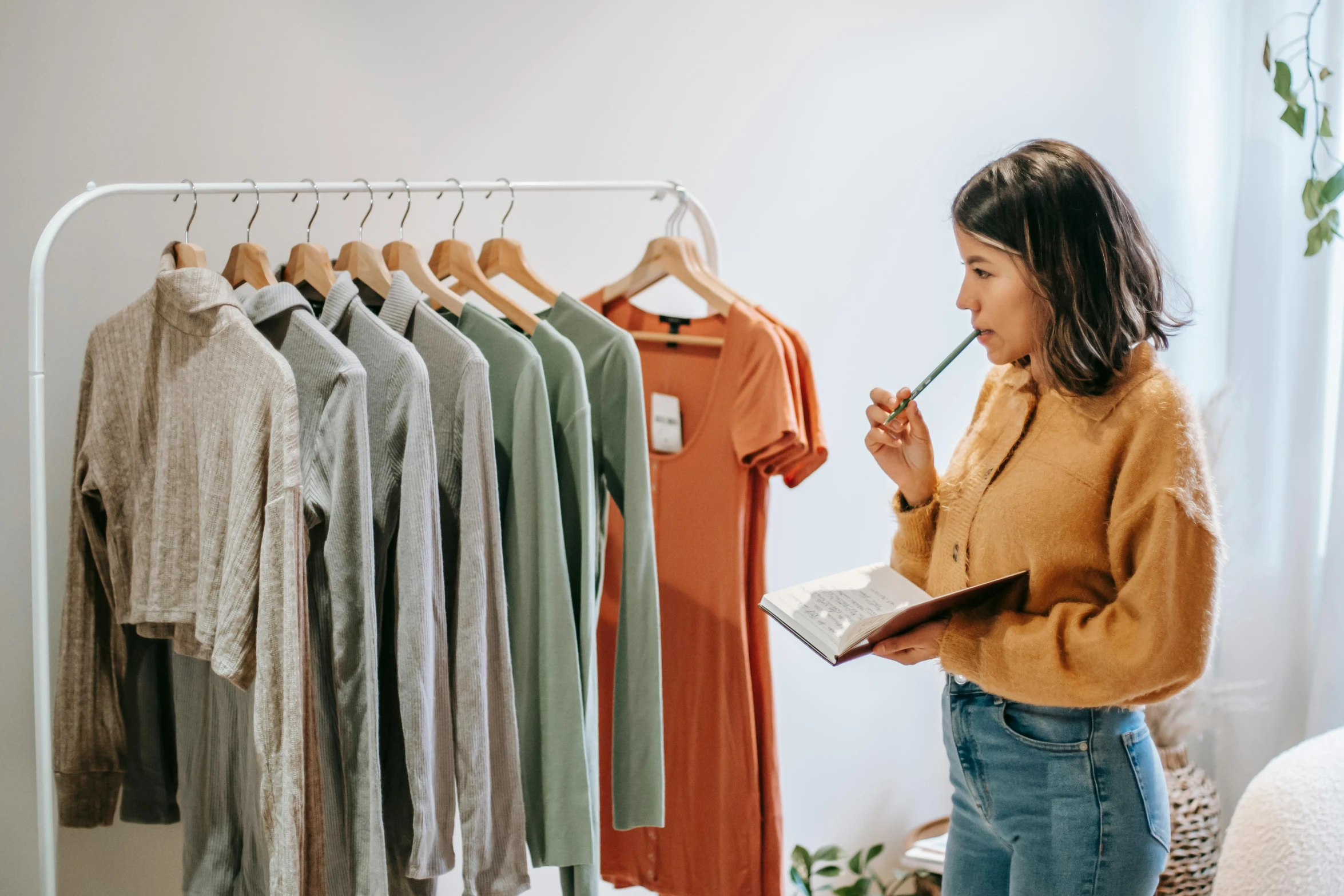 a woman standing in front of a rack of clothes, inspect in inventory image, indi creates, guide, for a catalogue