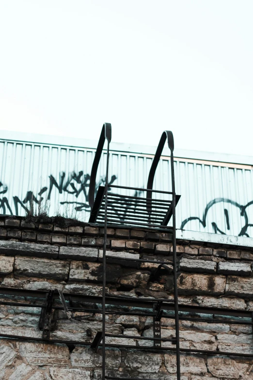a fire hydrant sitting on top of a brick building, trending on pexels, graffiti, ladder, sitting on a metal throne, view from the bottom, black graffiti