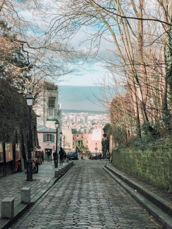 a cobblestone street in the middle of a city, a colorized photo, pexels contest winner, paris school, in the hillside, 🚿🗝📝