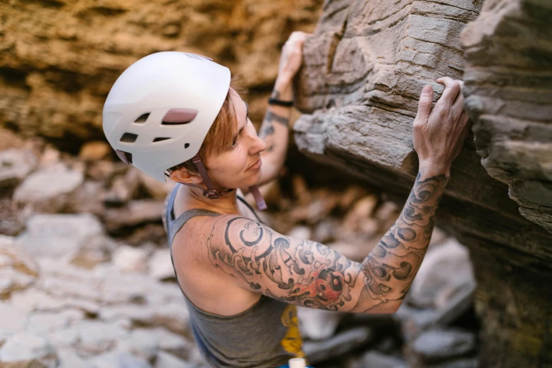 a person climbing on a rock with a helmet on, an epic non - binary model, profile image, no cutoff, very sweaty