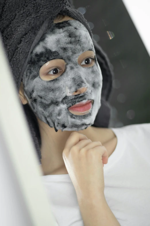 a woman is putting a mask on her face, by Daarken, textured base ; product photos, lava, cute looking, grey
