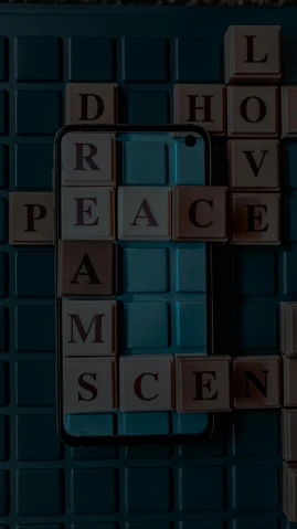 a close up of a cell phone with scrabbles on it, an album cover, inspired by Louise Nevelson, trending on unsplash, excessivism, peace atmopshere, cinema 4d cinematic render, peace and love, decoherence
