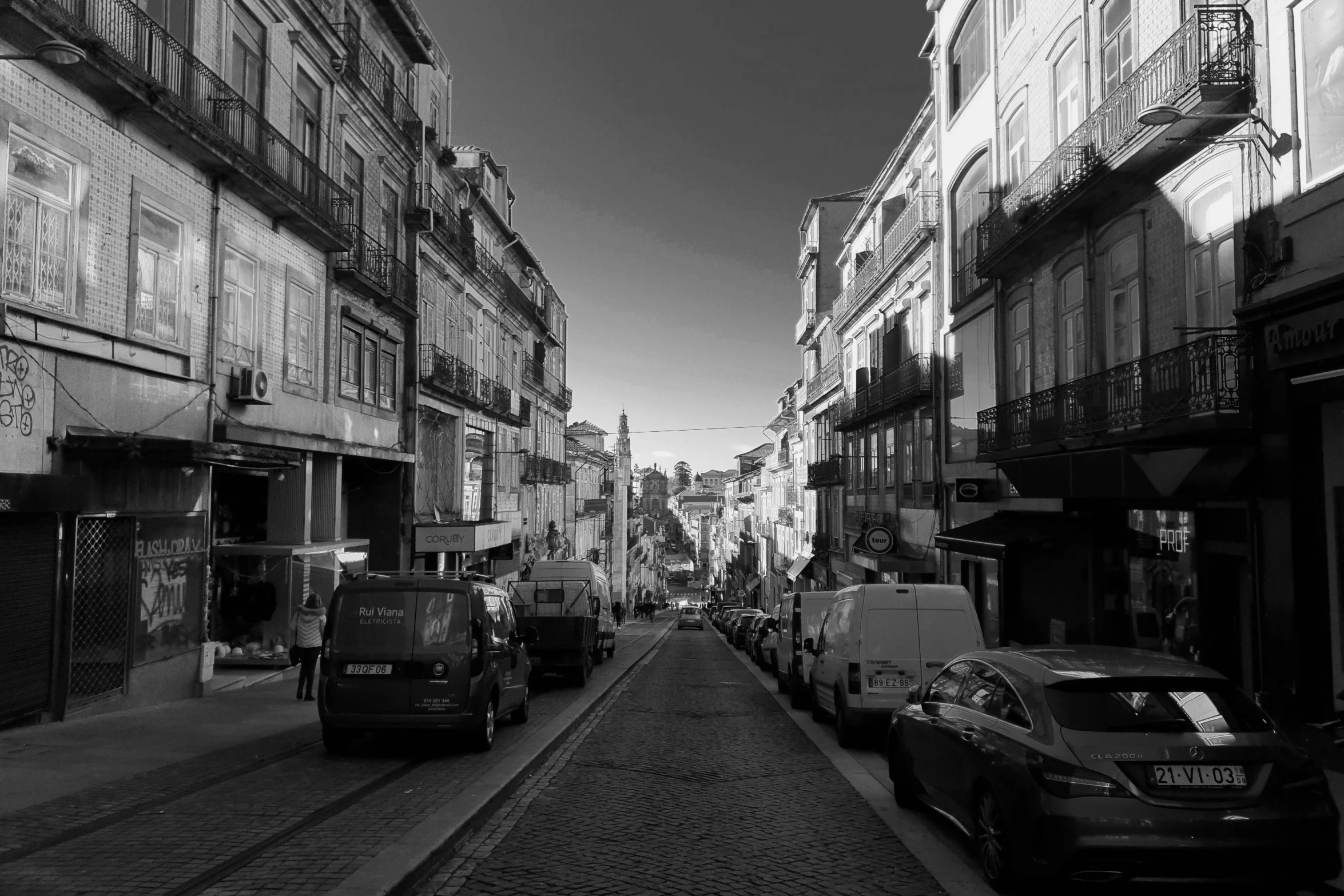 a black and white photo of a city street, by Nadir Afonso, pexels contest winner, renaissance, sunny day, portugal, late afternoon, car