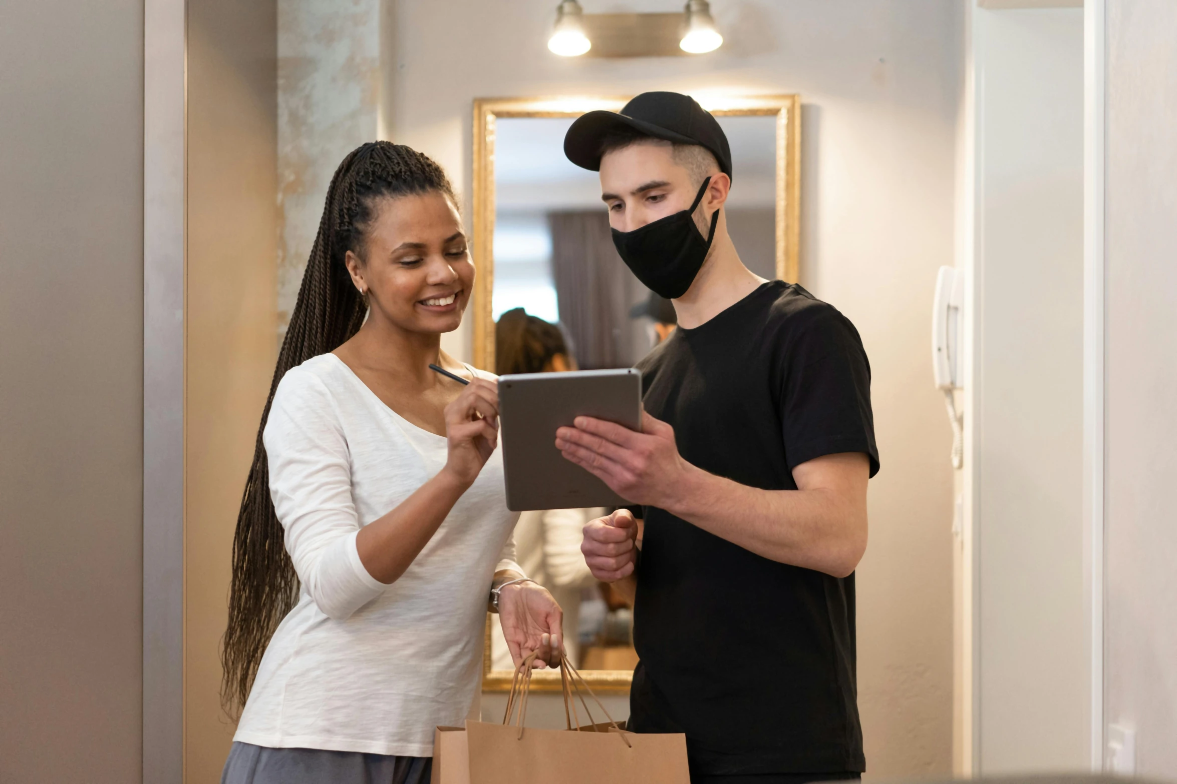 a man and a woman are looking at a tablet, pexels contest winner, white man with black fabric mask, delivering parsel box, customers, sydney hanson