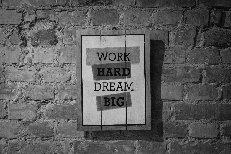 a sign on a brick wall that says work hard dream big, a poster, by Niko Henrichon, black - and - white photograph, a wooden, 15081959 21121991 01012000 4k, nimble