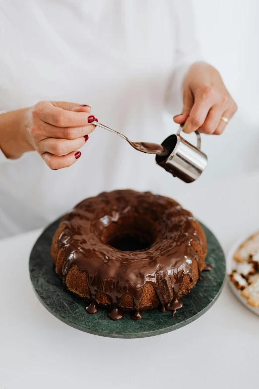 a woman sprinkles icing on a chocolate cake, a still life, trending on pexels, made of glazed, huge black round hole, shiny silver, thumbnail