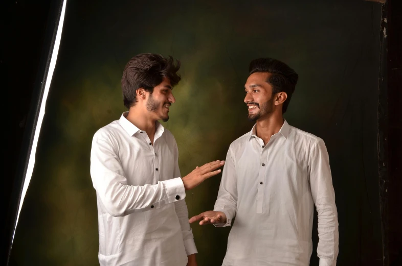 a couple of men standing next to each other, by Riza Abbasi, pexels contest winner, renaissance, wearing white shirt, improvisational, brothers, candid!! dark background