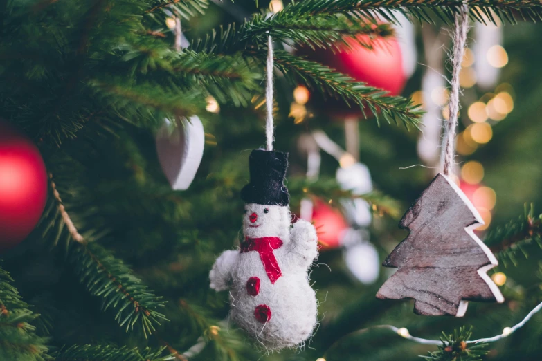 a snowman ornament hanging from a christmas tree, pexels, cosy, background image, rectangle, small
