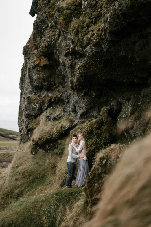 a man and woman standing on top of a cliff, a picture, by Else Alfelt, unsplash, renaissance, full frame image, standing in grassy field, natural cave wall, shallan davar