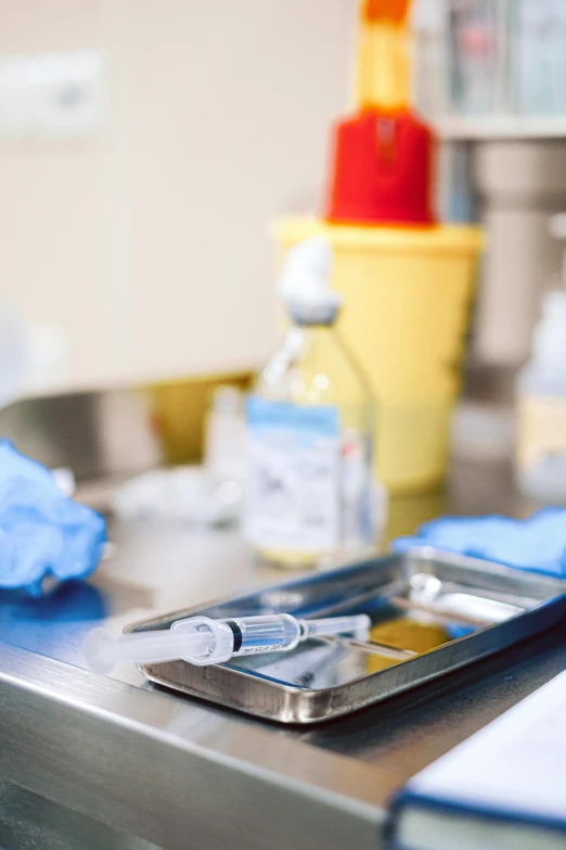 a cell phone sitting on top of a metal counter, a picture, by Dan Luvisi, shutterstock, holding a syringe, surgical gown and scrubs on, instagram photo, close-up shoot