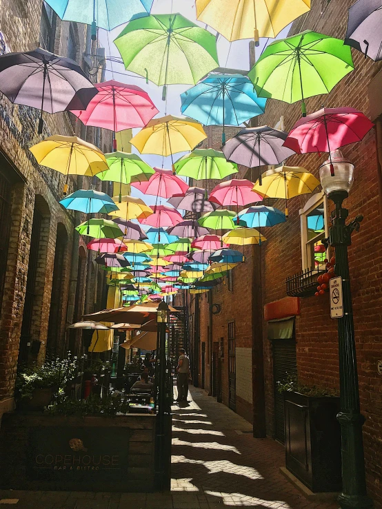 a street filled with lots of colorful umbrellas hanging from the ceiling, profile image, shady alleys, albuquerque, multiple stories