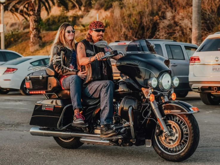 a man and woman riding on the back of a motorcycle, a portrait, by Lee Loughridge, pexels contest winner, golden hour in pismo california, avatar image, danny trejo, holiday season