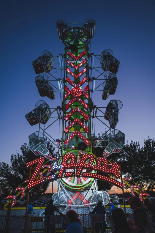 people standing around a carnival ride at night, pexels contest winner, kinetic art, zippers, tower, colorful signs, profile image