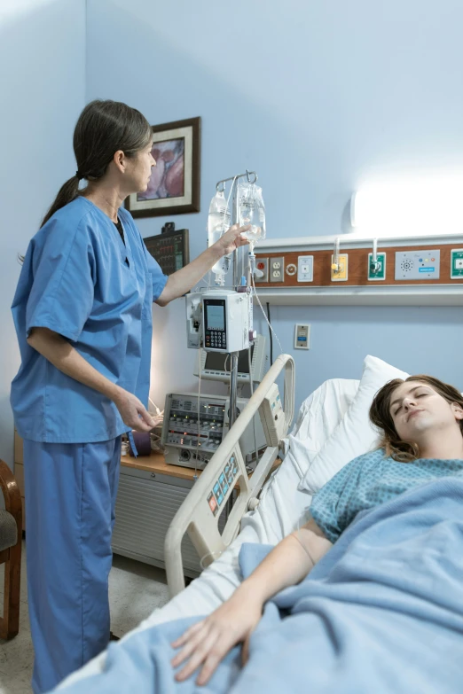 a woman laying in a hospital bed next to a nurse, happening, practical effects, transparent, blue, tall