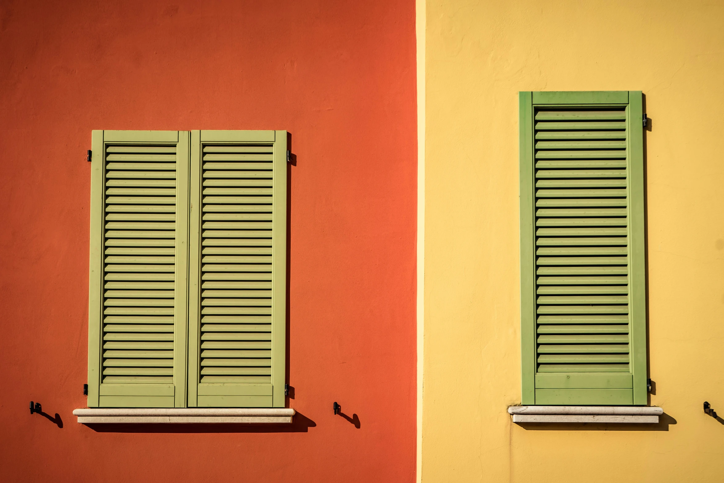 a couple of green shutters on the side of a building, inspired by Wes Anderson, pexels contest winner, yellow and red color scheme, italy, window light, 3 colors