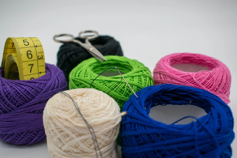 a bunch of balls of yarn next to a measuring tape, unsplash, intricate embroidery, high quality product image”, full dynamic colour, group photo