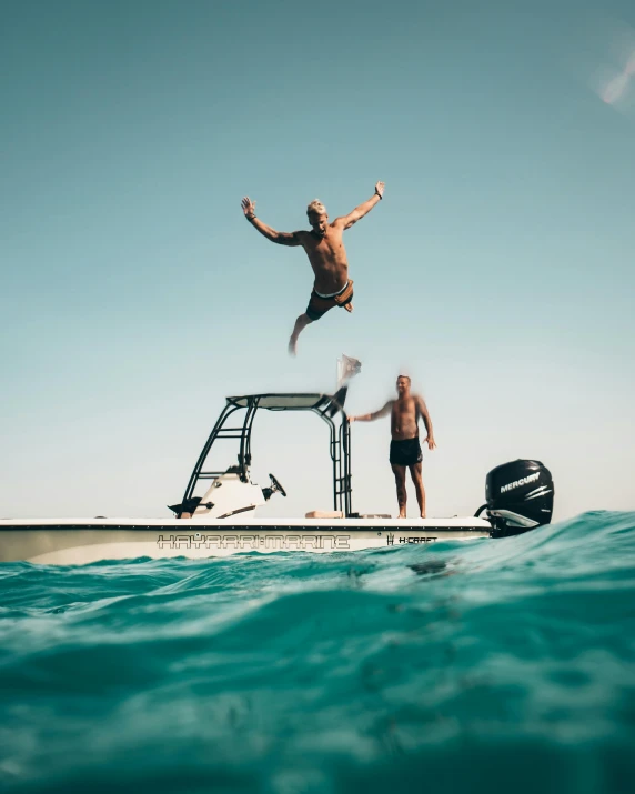 a man jumping off a boat into the water, by Adam Dario Keel, pexels contest winner, two male, proud looking, slightly tanned, reefs