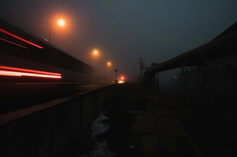 a train traveling over a bridge on a foggy night, inspired by Elsa Bleda, unsplash contest winner, graffiti, dark city bus stop, fog mads berg, high quality photo, shot on sony a 7