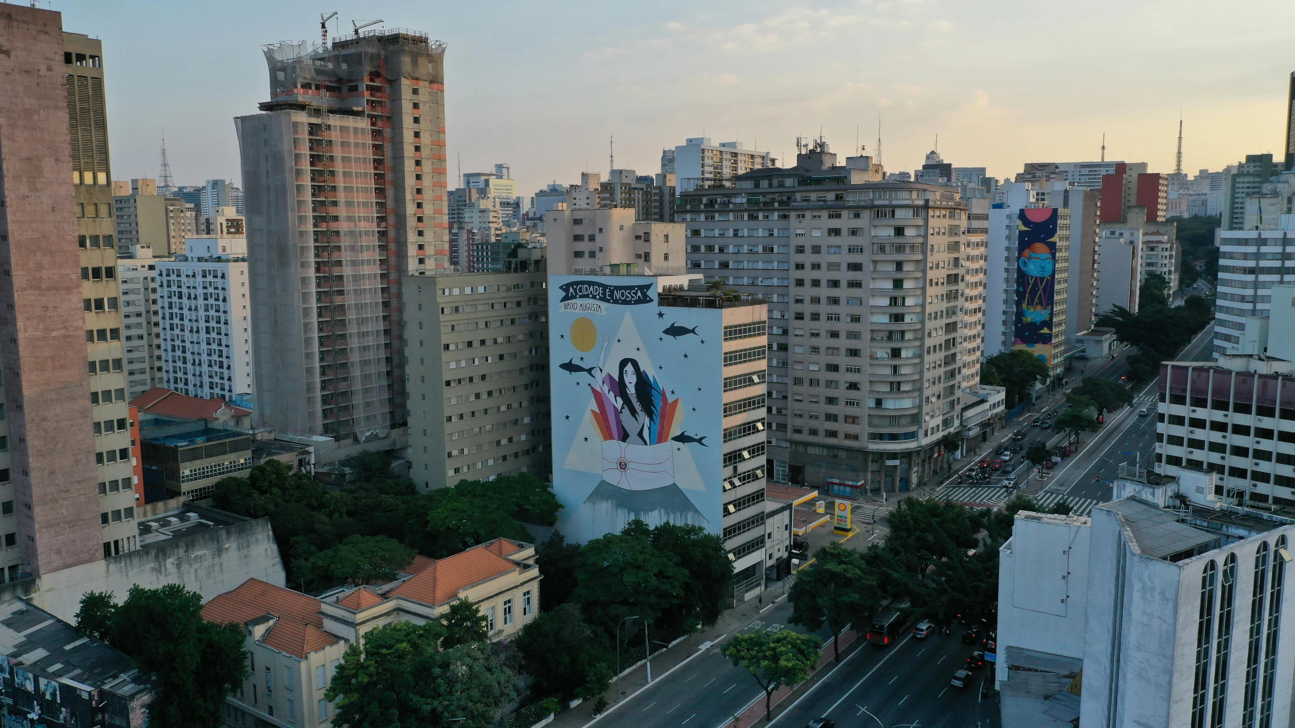 a city filled with lots of tall buildings, inspired by Francis Souza, street art, drone footage, advertising photo, fan favorite, subtitles