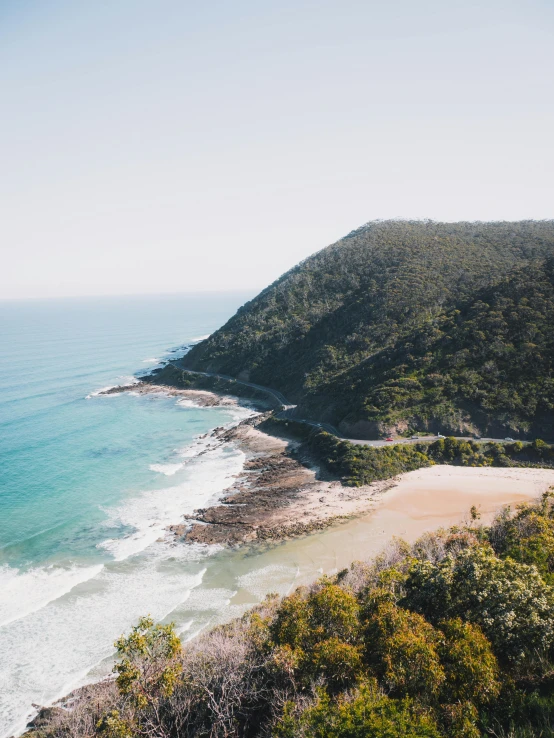 a view of a beach from the top of a hill, luxurious onsens, profile image, wide aerial shot, trees and cliffs