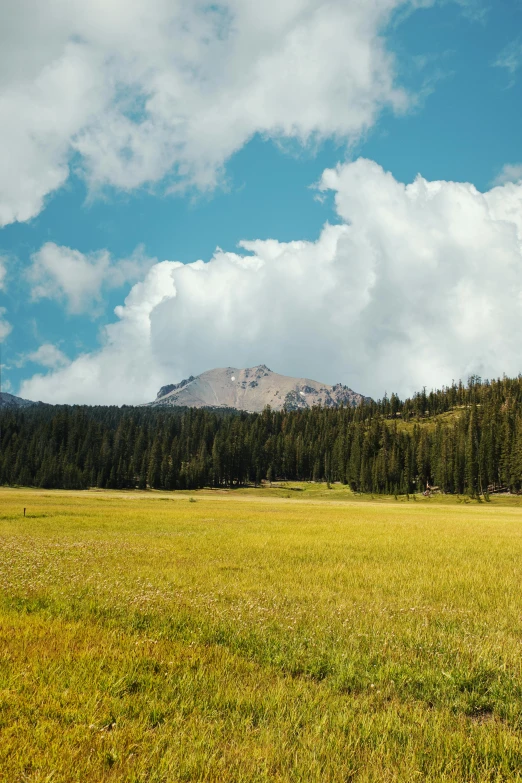 a man riding a horse across a lush green field, inspired by Albert Bierstadt, unsplash, les nabis, crater lake, 8 k wide shot, tall fluffy clouds, today\'s featured photograph 4k