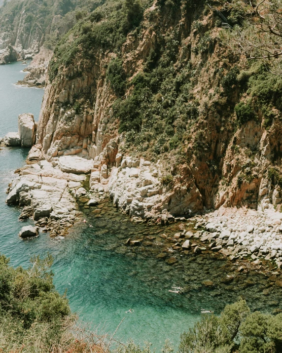 a large body of water sitting on top of a lush green hillside, pexels contest winner, cinq terre, 2 5 6 x 2 5 6 pixels, crystal clear water, rock formations