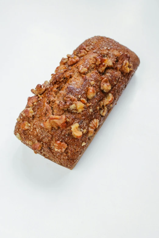 a loaf of bread sitting on top of a white surface, dessert, detailed product image, nut, orange