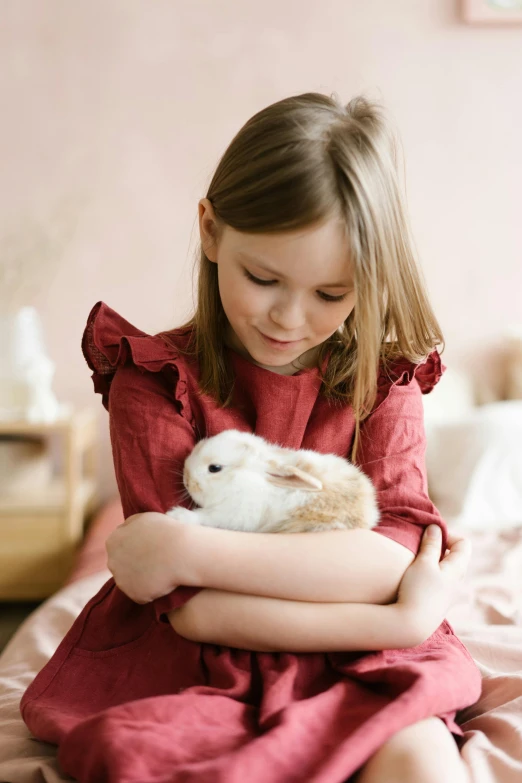 a little girl sitting on a bed holding a bunny, inspired by Beatrix Potter, trending on pexels, romanticism, hugging each other, small animals, full product shot, enamel