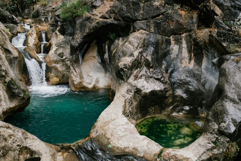 a pool of water surrounded by large rocks, unsplash contest winner, grotto, 2 5 6 x 2 5 6 pixels, gorge in the mountain, 90s photo