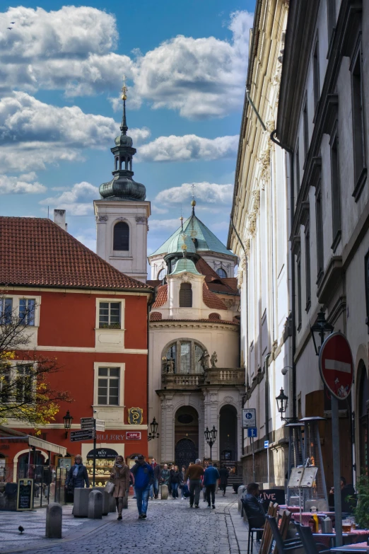 a cobblestone street with a clock tower in the background, a photo, by László Balogh, baroque, with great domes and arches, red roofs, cubic, square