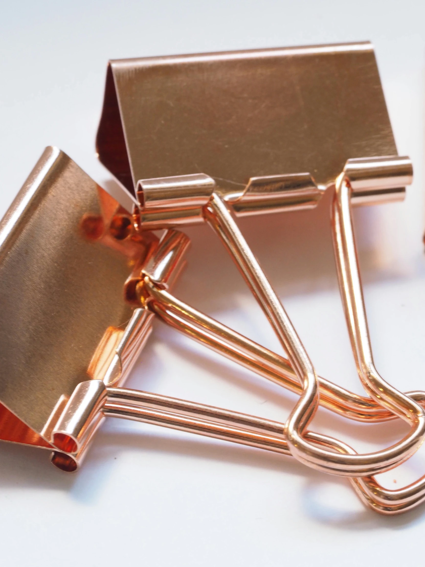 a bunch of paper clips sitting on top of a table, rose gold, hammers, detailed product image, photographed for reuters