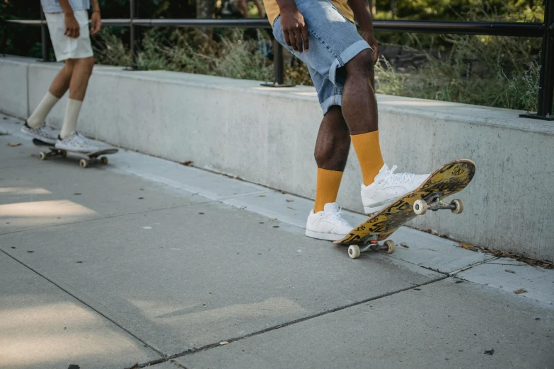 a man riding a skateboard down a sidewalk, pexels contest winner, white and gold color scheme, socks, wearing yellow croptop, harriet tubman skateboarding