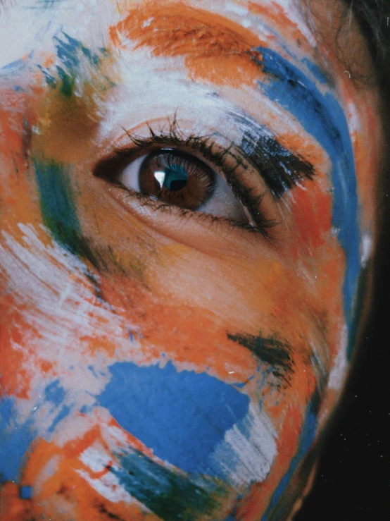 a close up of a person with paint on their face, an album cover, trending on unsplash, hyperrealism, blue and orange palette, indian, open eye freedom, girl with white eyes