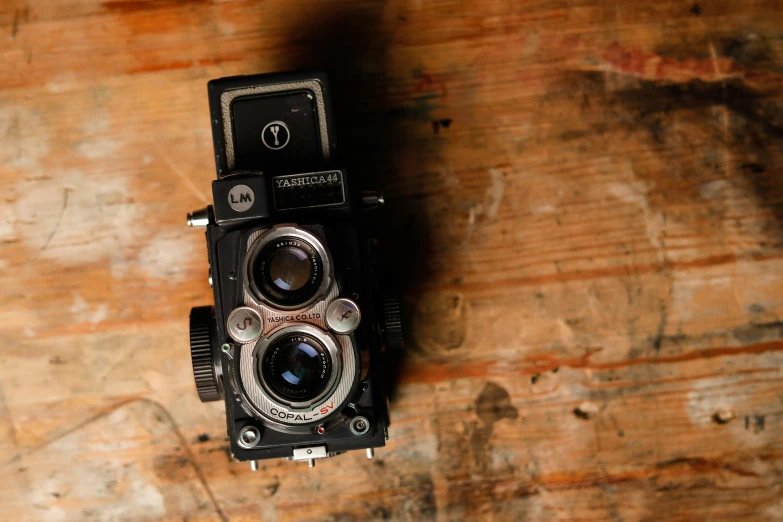 an old camera sitting on top of a wooden table, by Glennray Tutor, unsplash, photorealism, square, rolleiflex tlr, high quality photo, celluloid