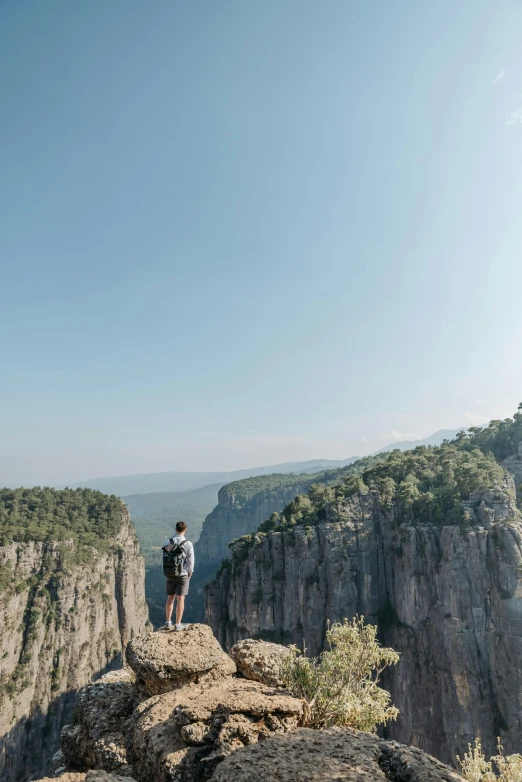 a couple of people standing on top of a mountain, les nabis, deep chasm, wide views, adam ondra, facing away