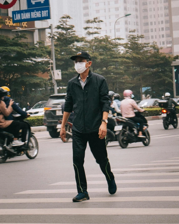 a man wearing a face mask crossing a street, trending on unsplash, vietnam, lgbt, polluted, 🚿🗝📝