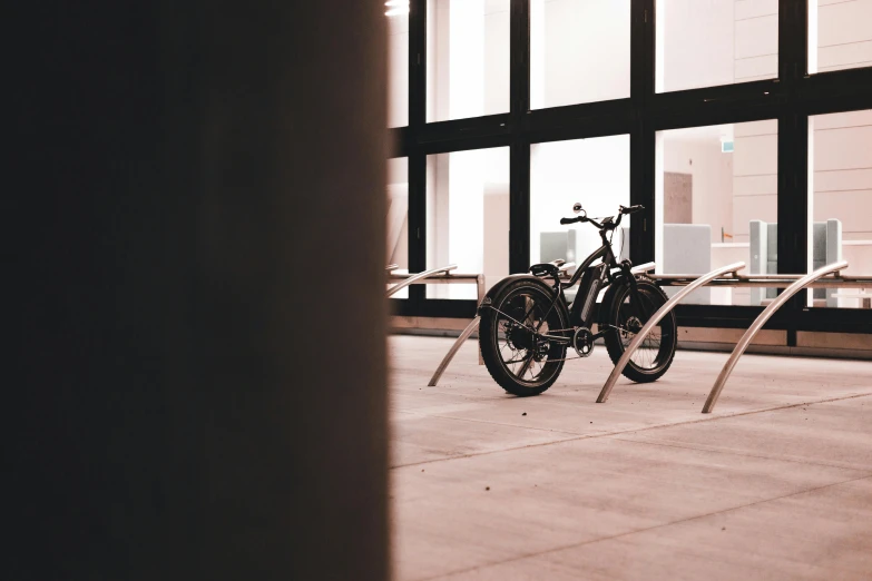 a bike is parked in front of a window, on a white table, curvy build, magnum opus, thumbnail