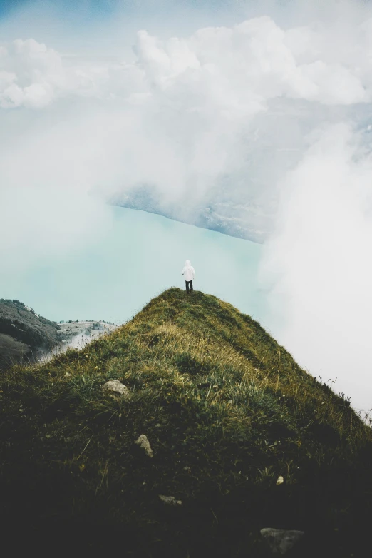 a person standing on top of a green hill, body of water, in the swiss alps, trending on vsco, cyan mist