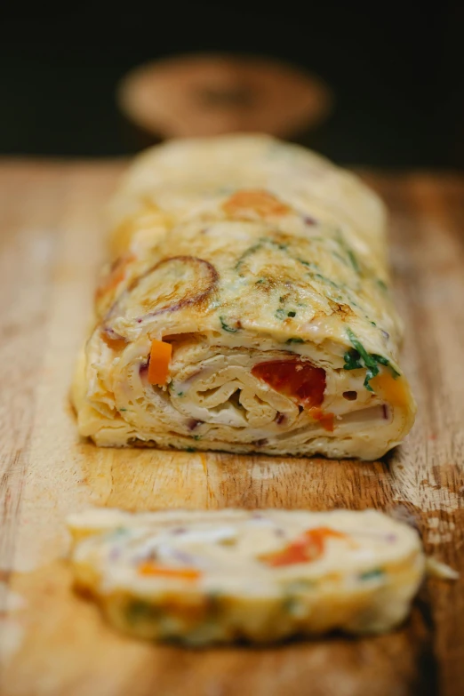 a close up of a piece of food on a cutting board, by Arthur Pan, reddit, wrapped arms, napoleon, colorful”, soft - warm