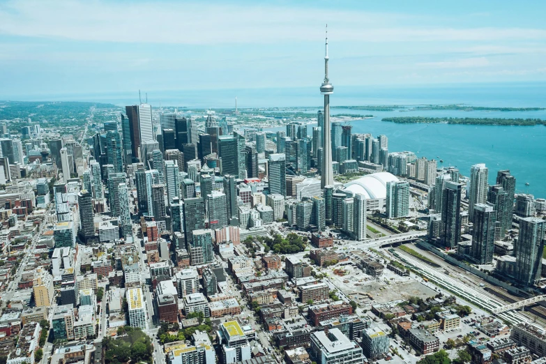 a view of a city with a lot of tall buildings, by Carey Morris, pexels contest winner, hurufiyya, cn tower, aerial footage, jen atkin, bright sunny day