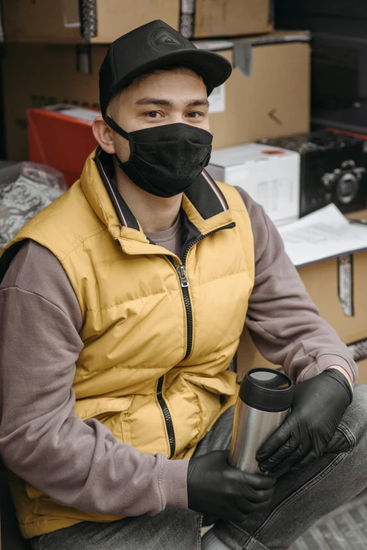 a man sitting in a chair wearing a face mask, inventory item, wearing a vest, heavy-duty boots, muted brown yellow and blacks