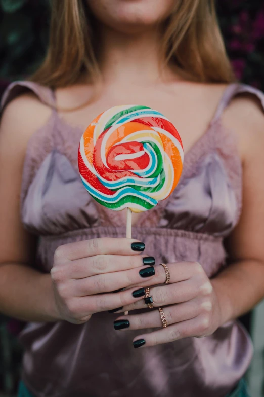a close up of a person holding a lollipop, colorful dress, perfectly poised, 👅 👅