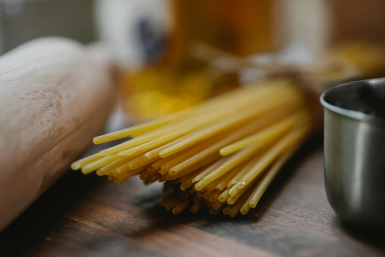 a bunch of spaghetti sitting on top of a wooden table, cooking oil, profile image, fan favorite, handcrafted