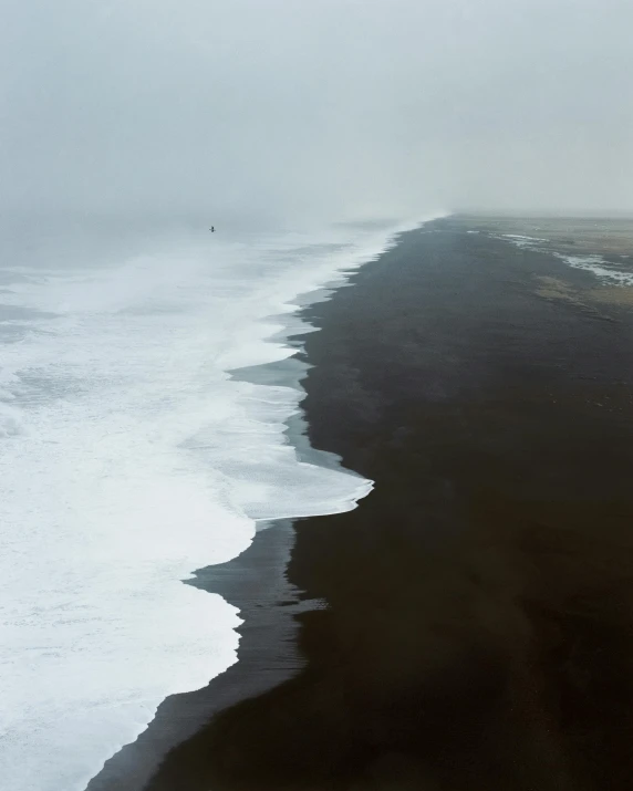 a large body of water next to a beach, by Alison Geissler, flowing with dark power, north pole, annie lebowitz, black volcano afar