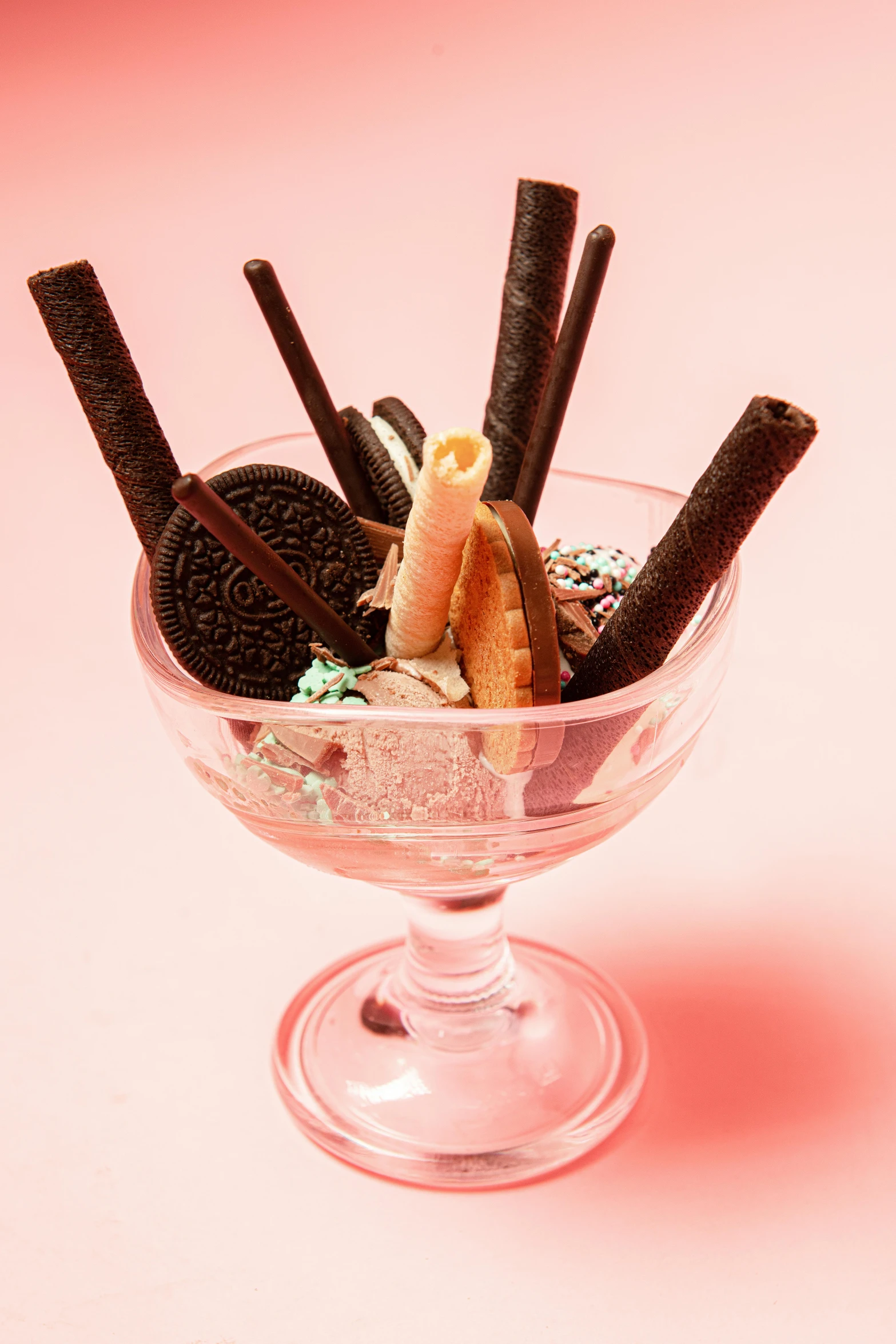 a glass bowl filled with ice cream and cookies, googie kitsch aesthetic, licorice allsort filling, tiny sticks, promo image