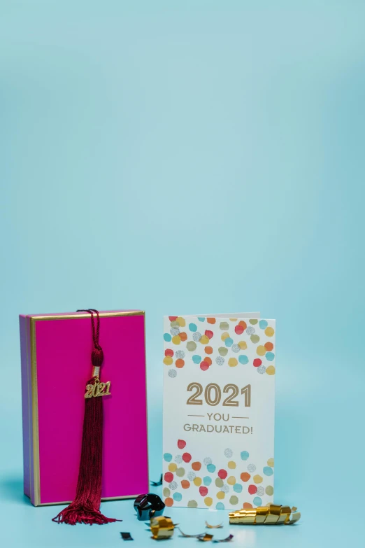 a book sitting on top of a table next to a notebook, tassels, 2 0 2 1, grand!, multi colored