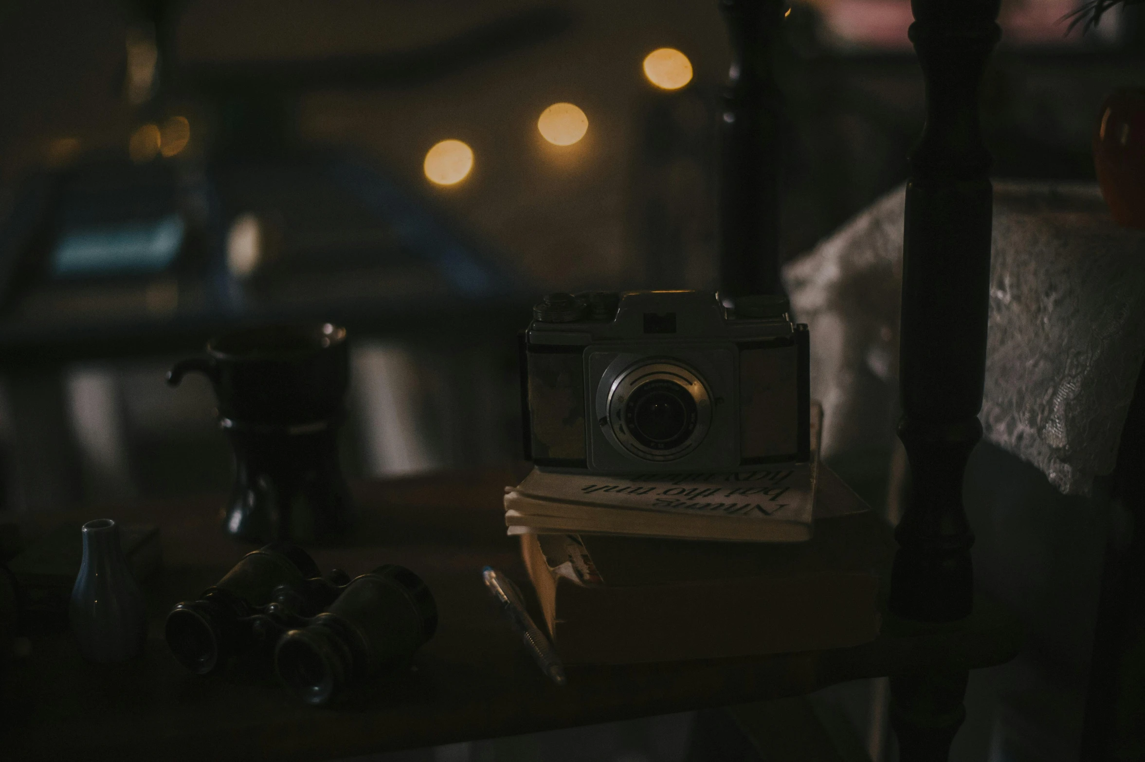 a camera sitting on top of a wooden table, dimly lit scene, mcu photograph, low quality photo