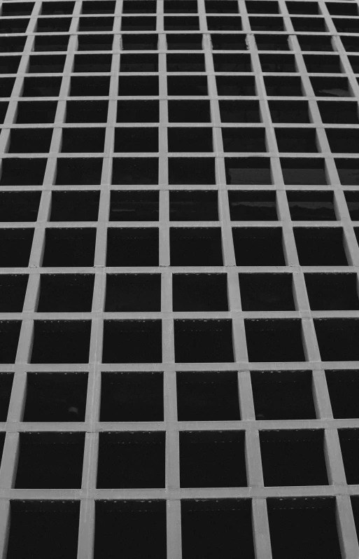 a black and white photo of a tall building, inspired by Andreas Gursky, unsplash, minimalism, floor grills, square, storm drain, two